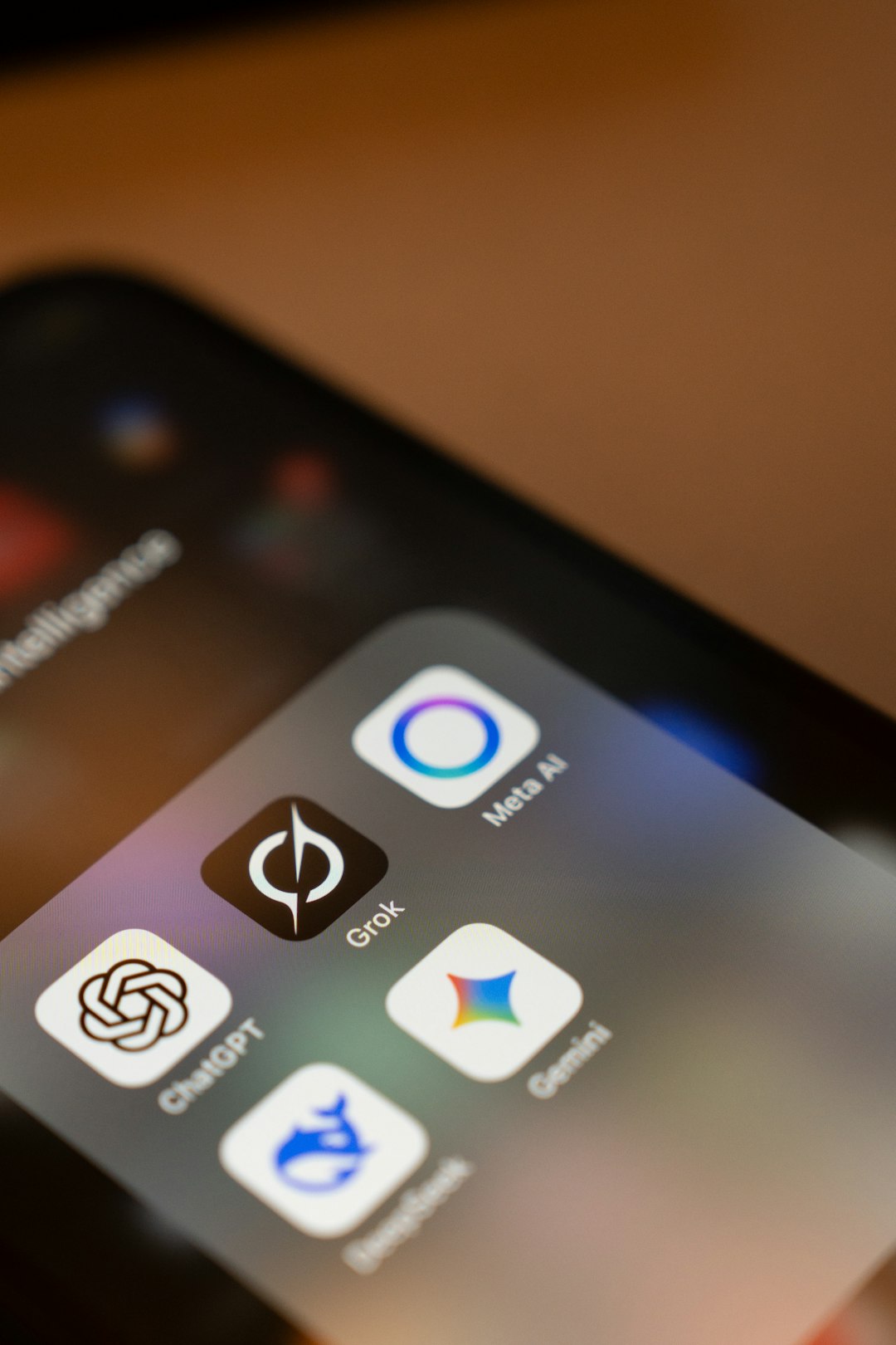 Close-up macro shot of a smartphone screen showing the Grok AI app icon alongside other popular AI apps including ChatGPT, Google Gemini, and Meta AI.